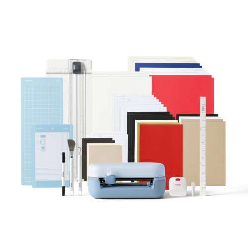 Cricut cutting machine with assorted colored paper packs mats rulers and craft tools on a white background