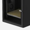 Interior of a black 3D printer showing the build plate and rear wheel with Bambu Lab branding visible on the door lever