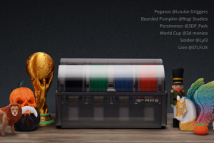 Bambu Lab AMS 3D printer with transparent lid and four colored filament spools on a wooden table surrounded by Halloween decorations pumpkin lion figure unicorn with rainbow wings