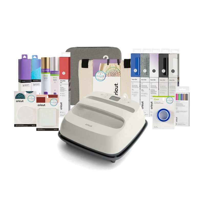 Cricut cutting machine centered among packaging and accessories for vinyl, pens, and mats in a craft bundle.